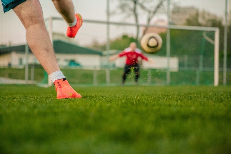 A player kicking a ball towards a goal