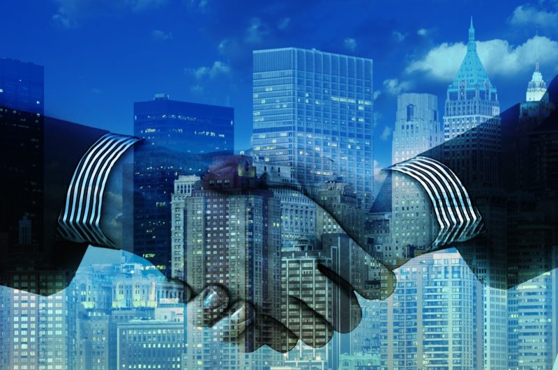 A handshake Two hands shaking with skyscrapers in the background
