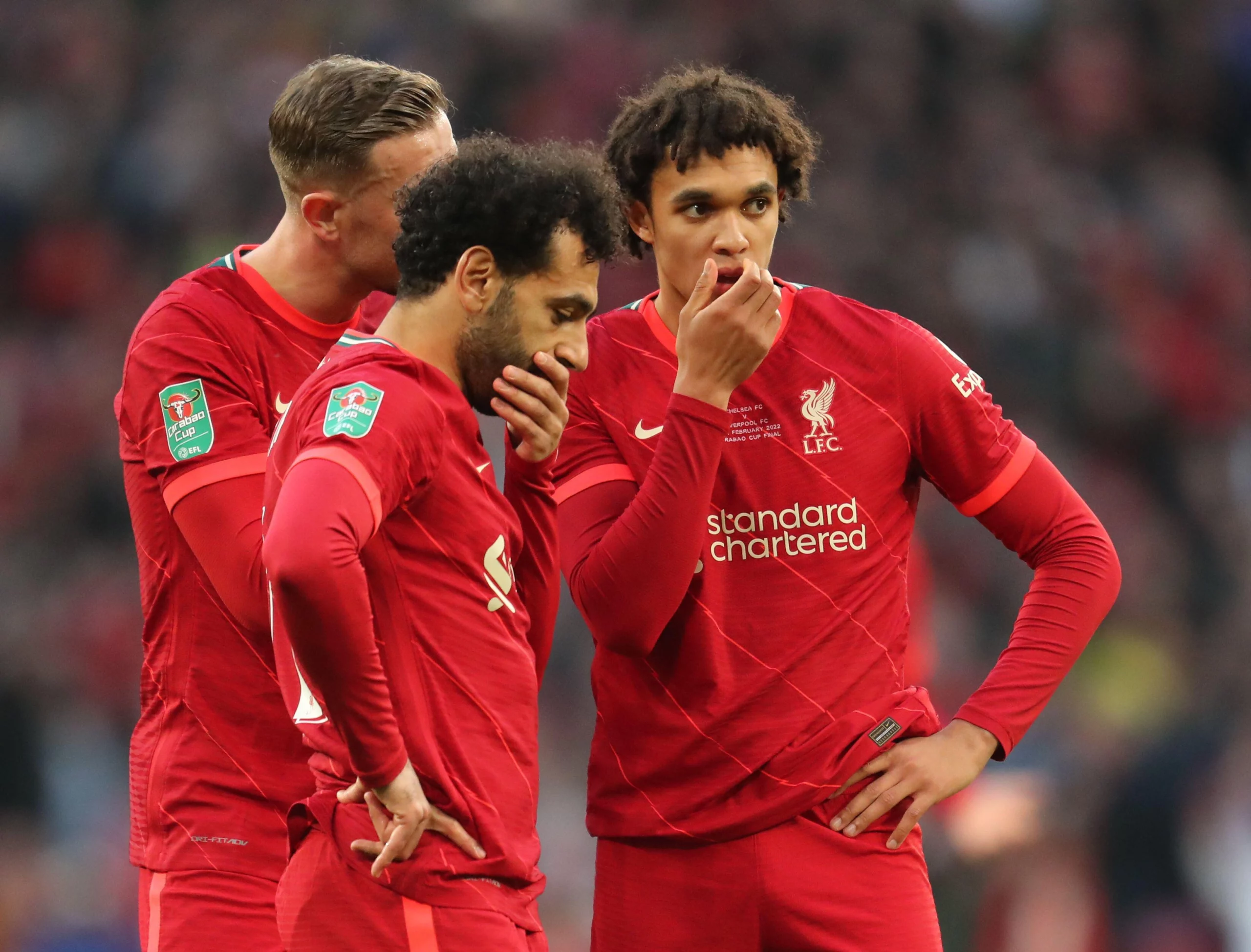 Alexander Arnold and Mo Salah contemplating a situaiton on a pitch