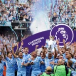 Manchester City players celebrate with trophy after winning the 2022 English Premier League title